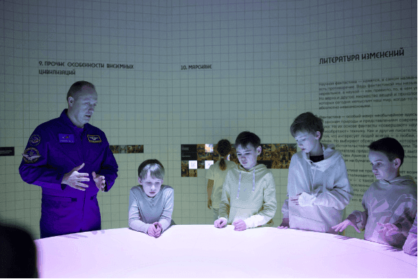 Alexander Misurkin with children at an interactive table at an exhibition