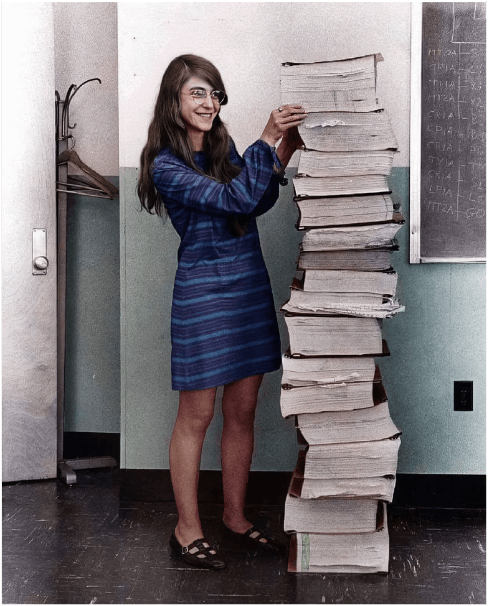 Margaret Hamilton, NASA's lead programmer for the Apollo program, next to a stack of program printouts